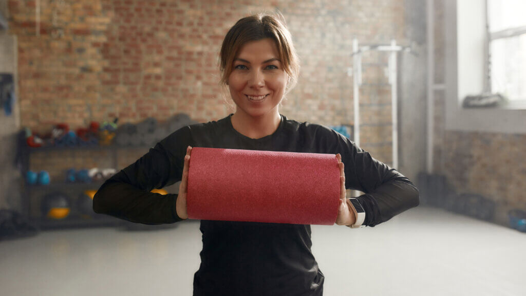 Mujer usa el rodillo para hacer ejercicios de propiocepción para los hombros.