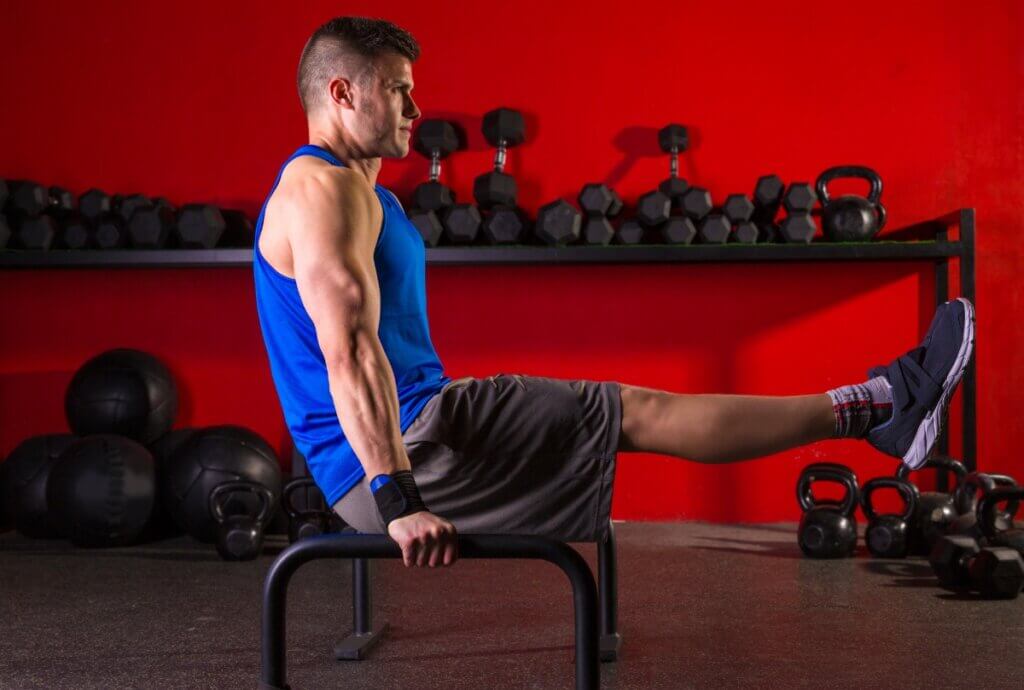 Hombre haciendo ejercicio con barras paralelas.