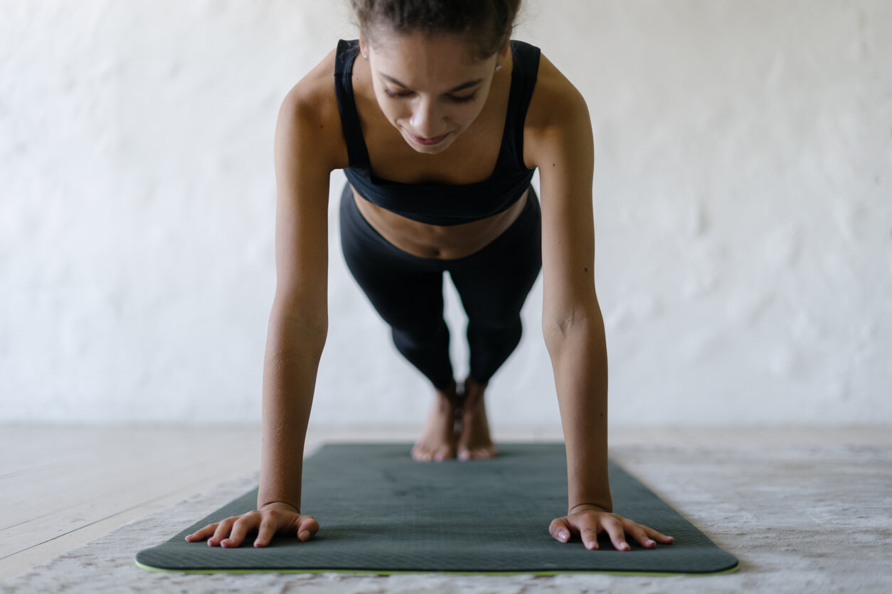 Mujer aprendiendo cómo hacer bien una plancha abdominal