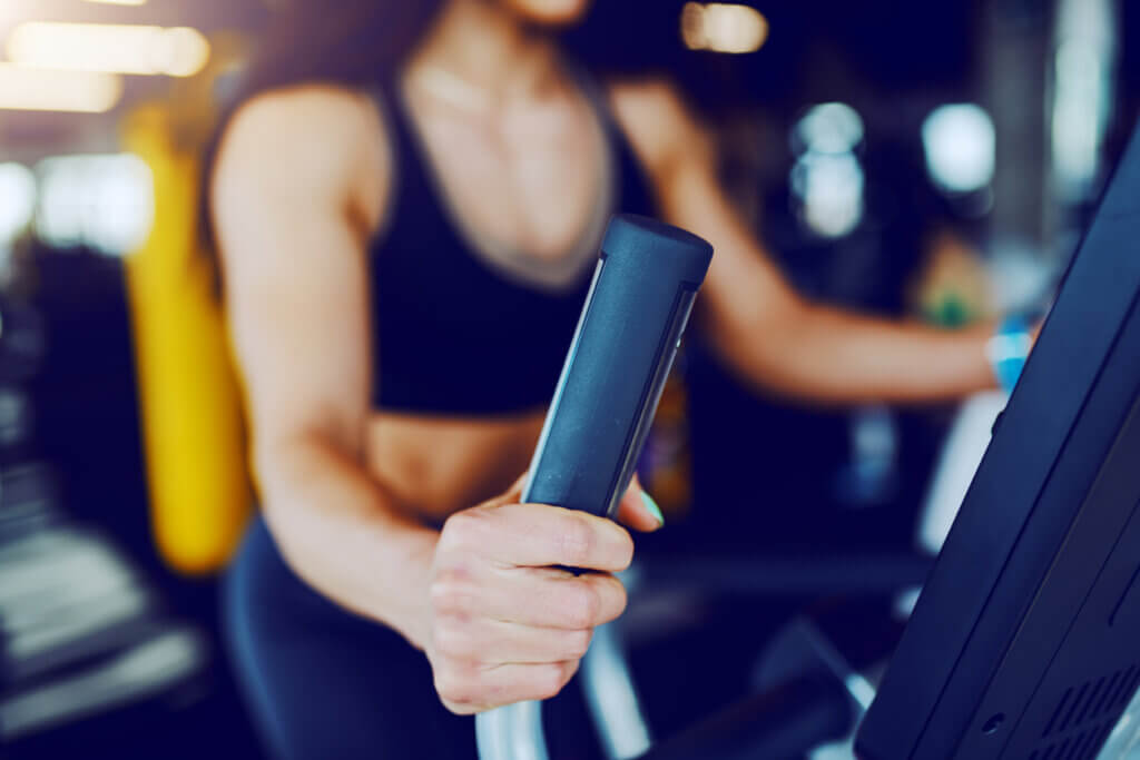 Mujer entrenando cardio en máquina elíptica