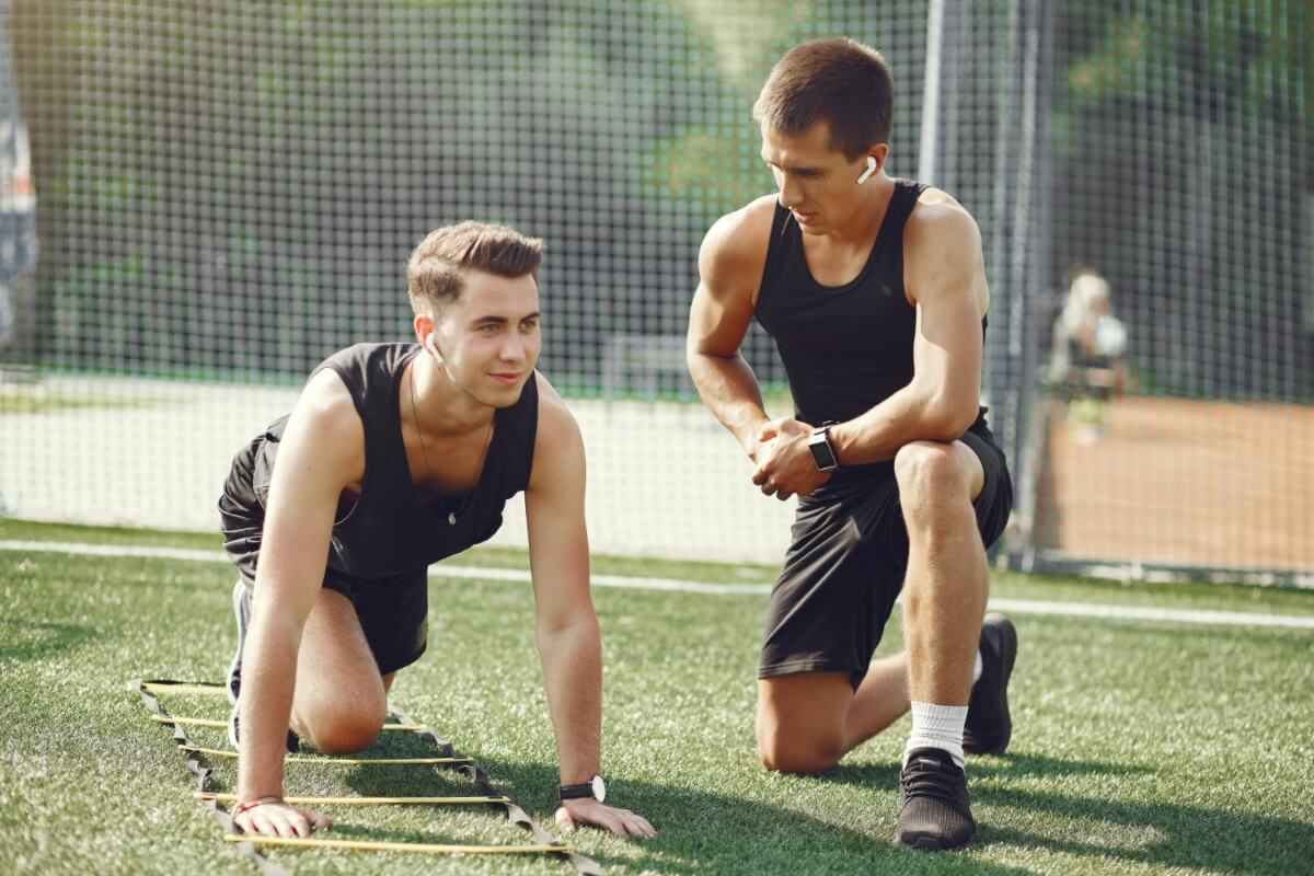 Coach hablando con deportista en el gimnasio.